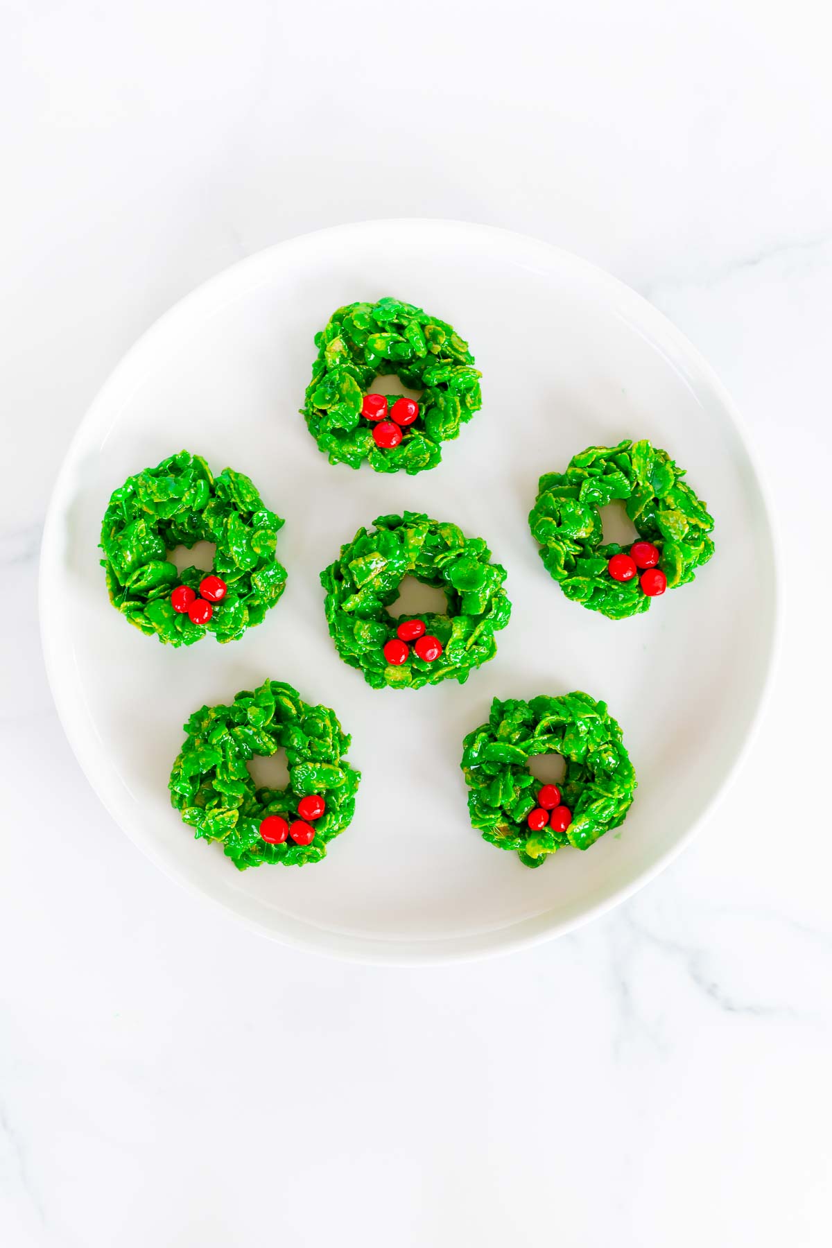 christmas wreath cookies on white plate