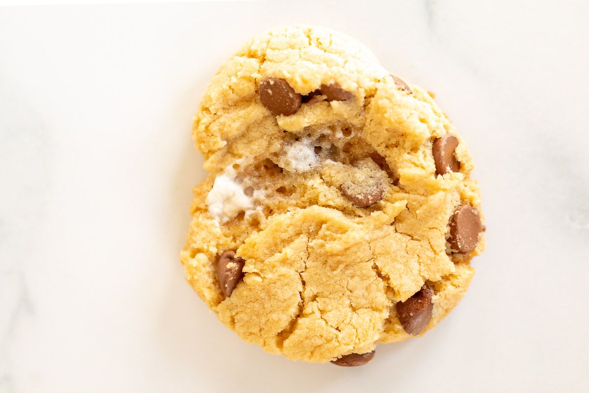A single homemade marshmallow cookie on a marble surface.