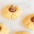 Peanut butter blossoms on a white marble surface.