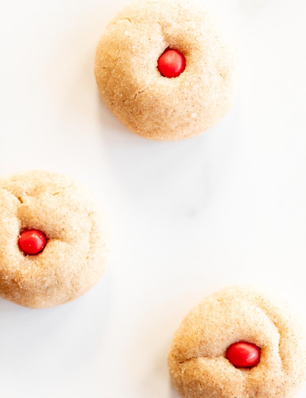 thick cinnamon cookies with red hots in center