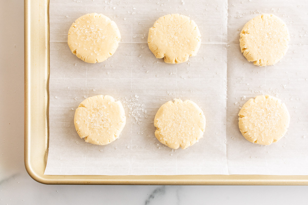 pressed sugar cookies on parchment lined baking sheet