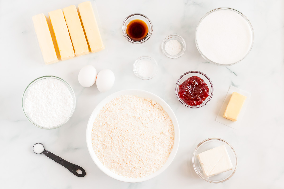 Ingredients for strawberry cheesecake cookies laid out on a marble surface.