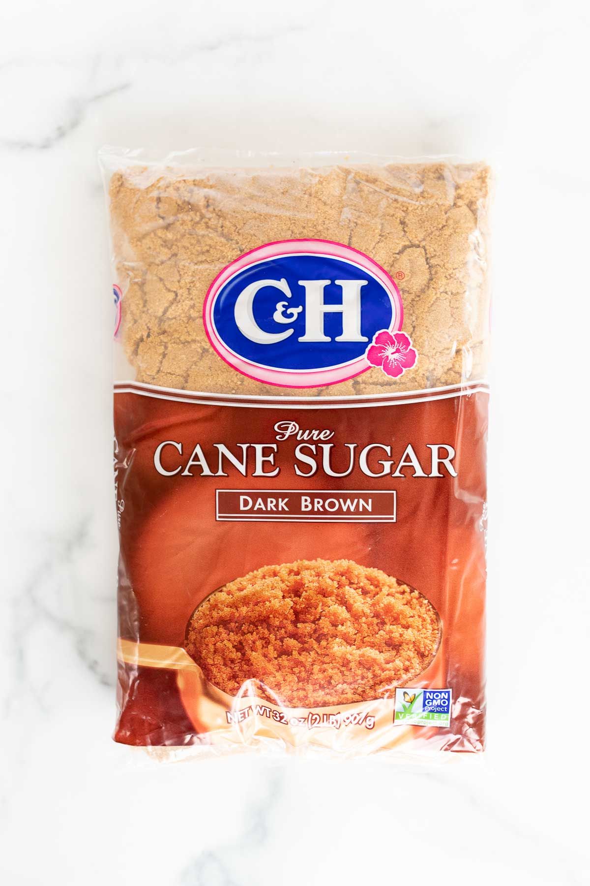 A bag of dark brown sugar on a marble countertop.