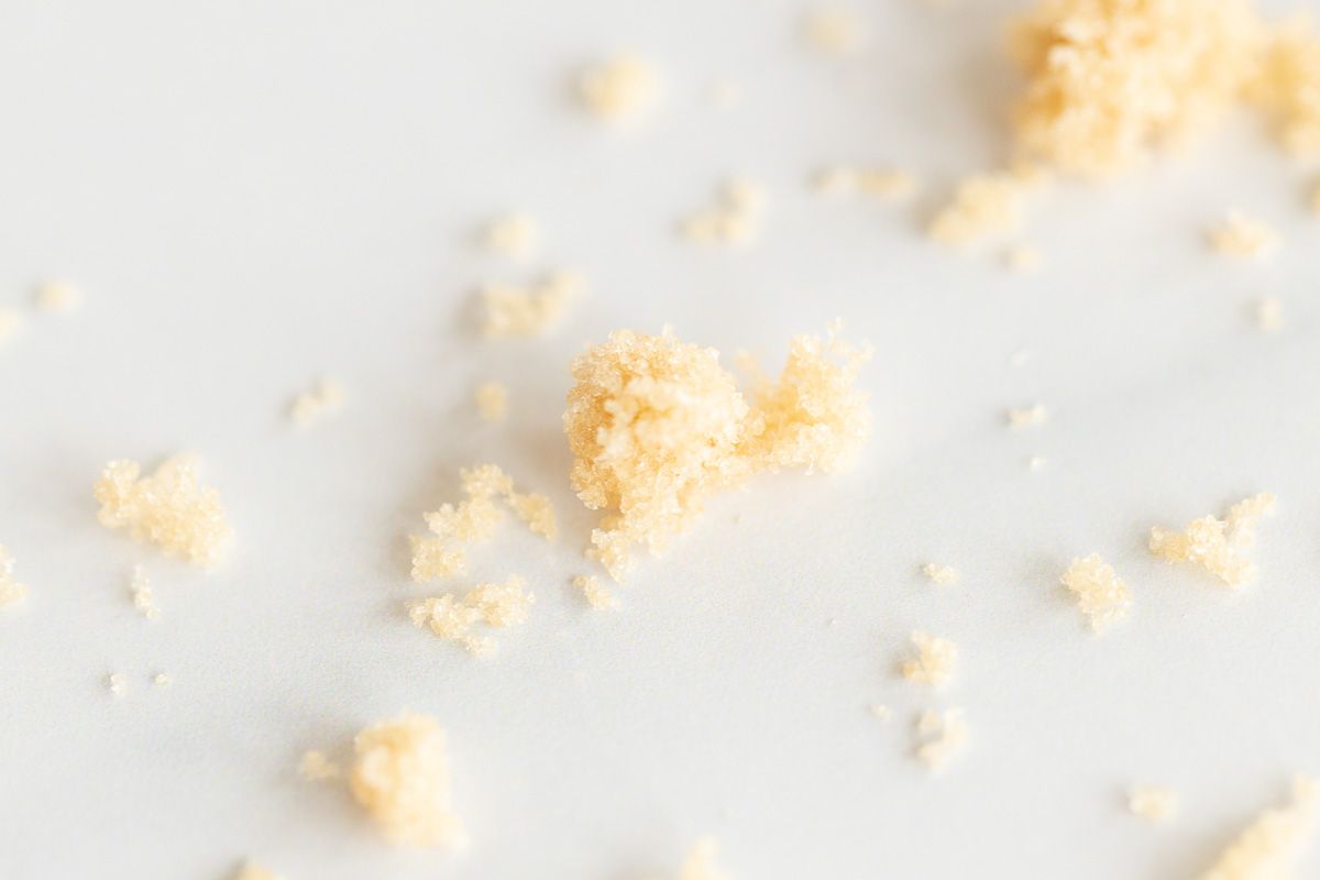 light brown sugar scattered on a marble surface.