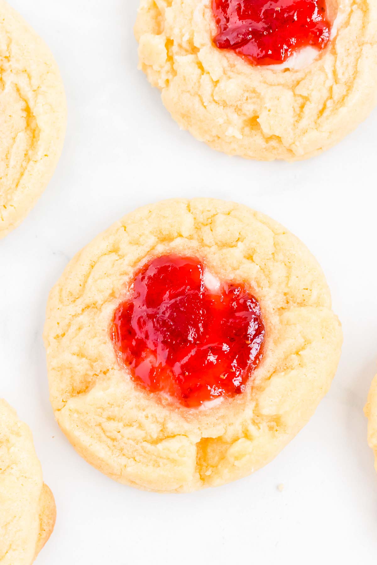 A strawberry cheesecake cookie on a white plate.