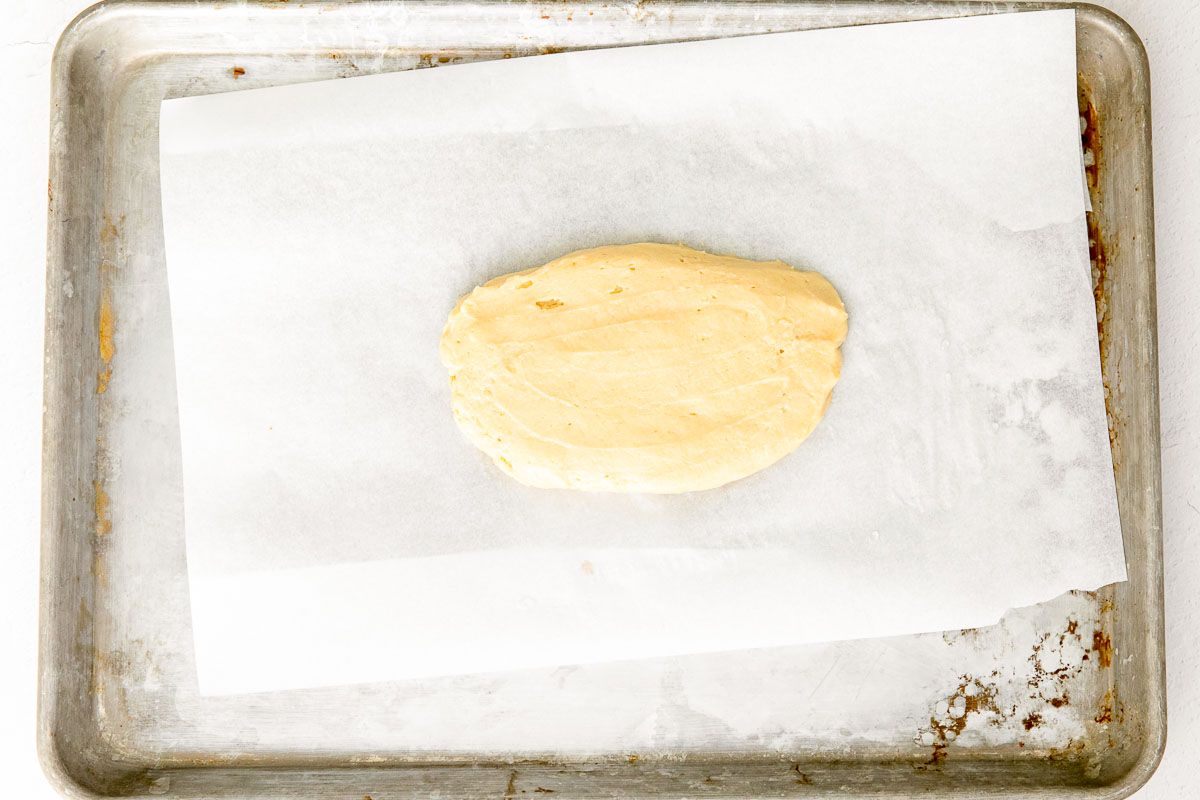 Biscotti dough on a parchment paper lined baking sheet.