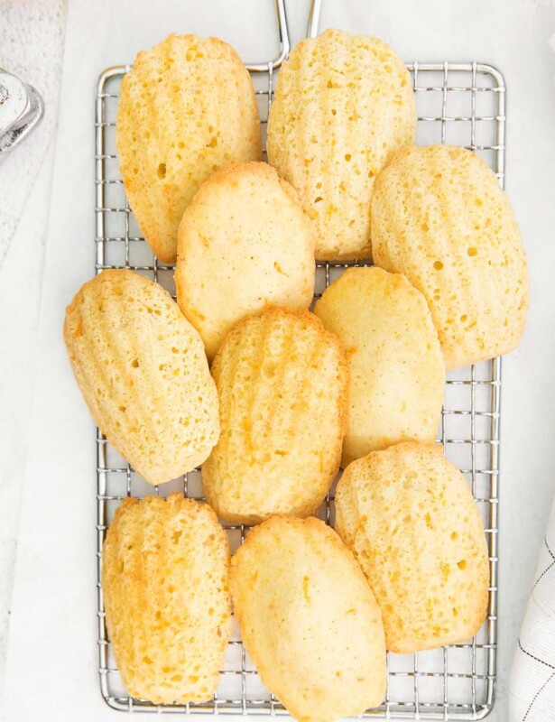 orange madeleines on a wire cooling rack.