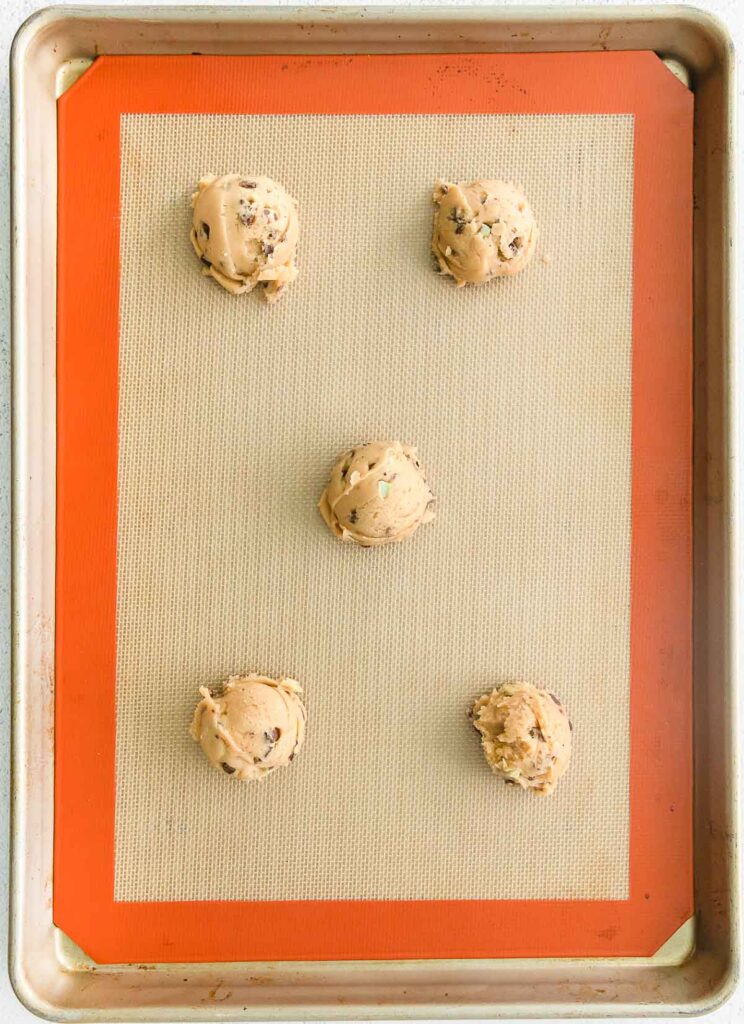 Scooping cookie dough with dough scoop into a baking sheet lined with  parchment paper to bake soft oatmeal raisin walnut cookies Stock Photo -  Alamy