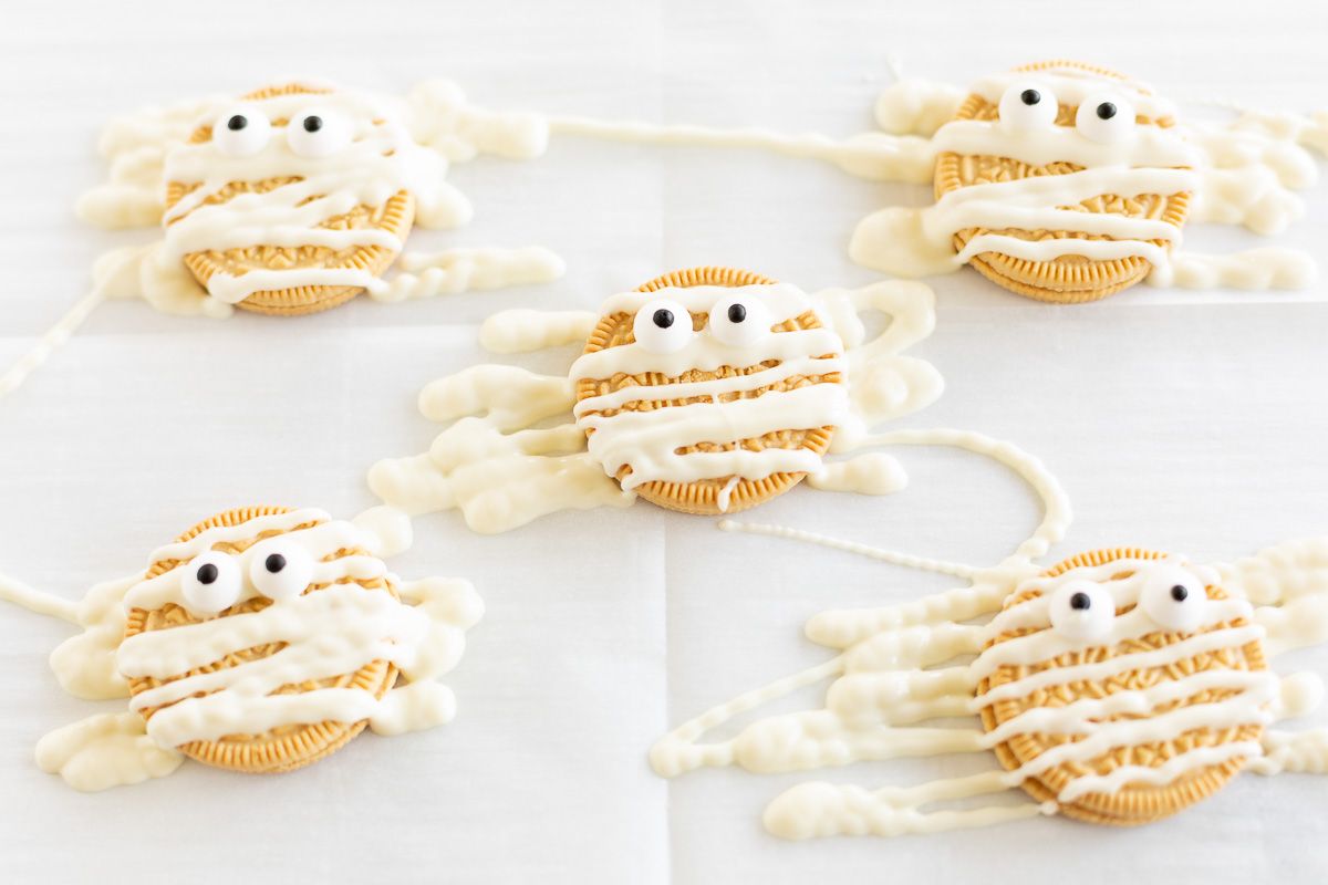 Halloween Oreos decorated as mummy cookies on parchment paper