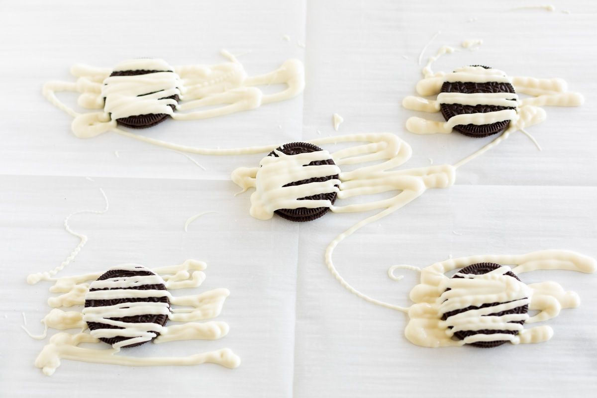 Halloween Oreos decorated as mummy cookies on parchment paper
