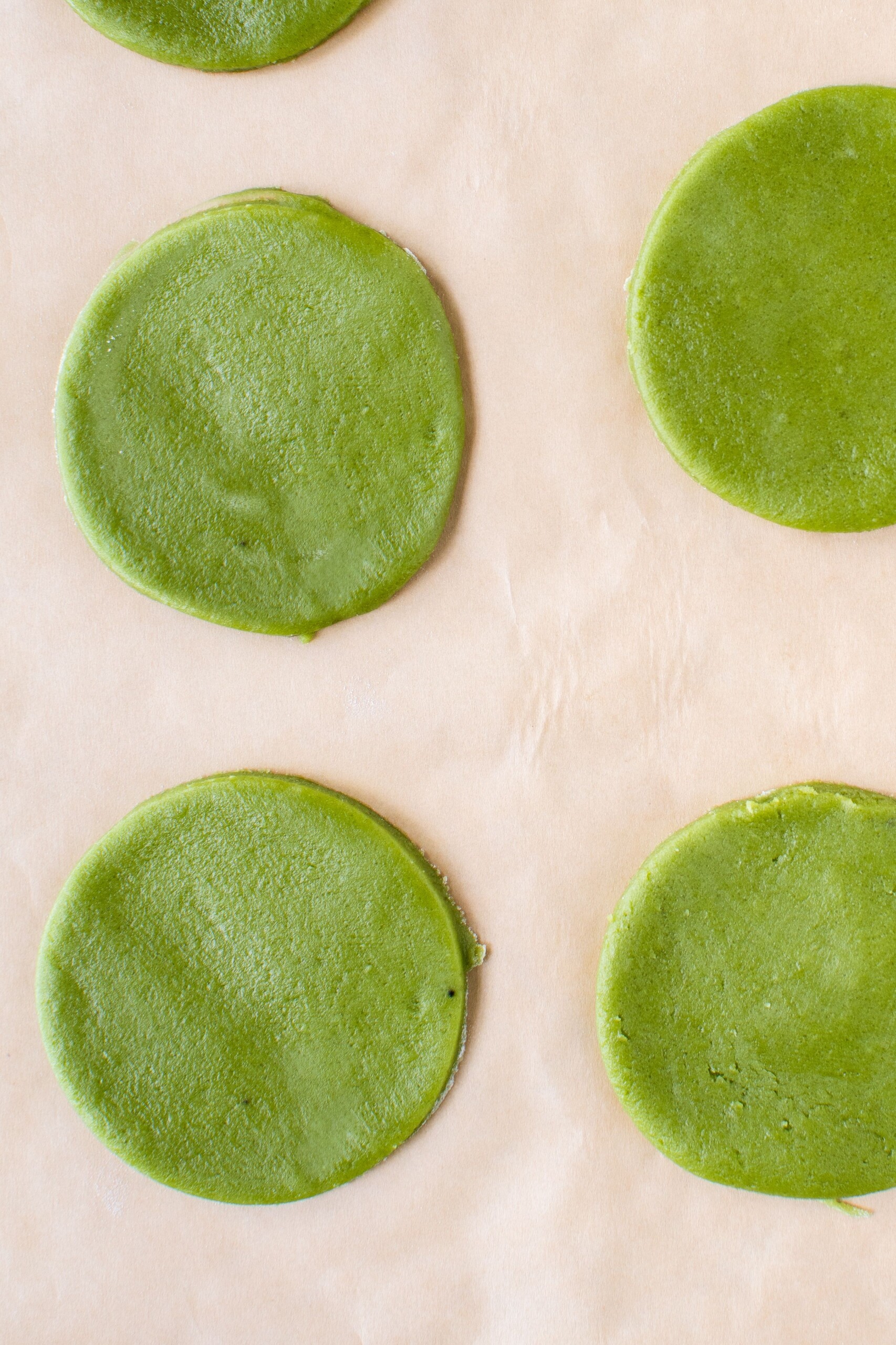 Green Matcha cookies before baking, laid on a baking sheet with parchment paper