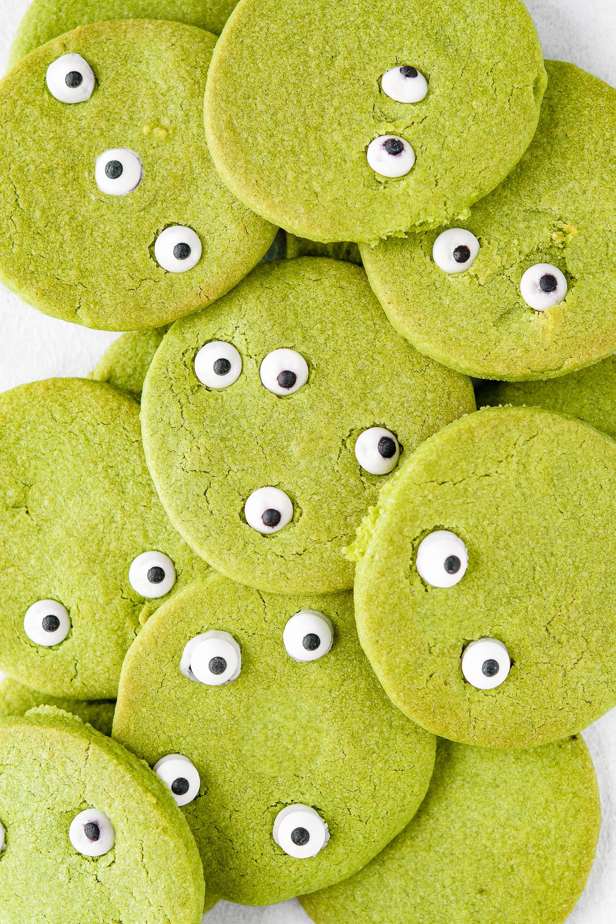 Matcha cookies for Halloween, round green cookies with candy eyes for a monster effect.