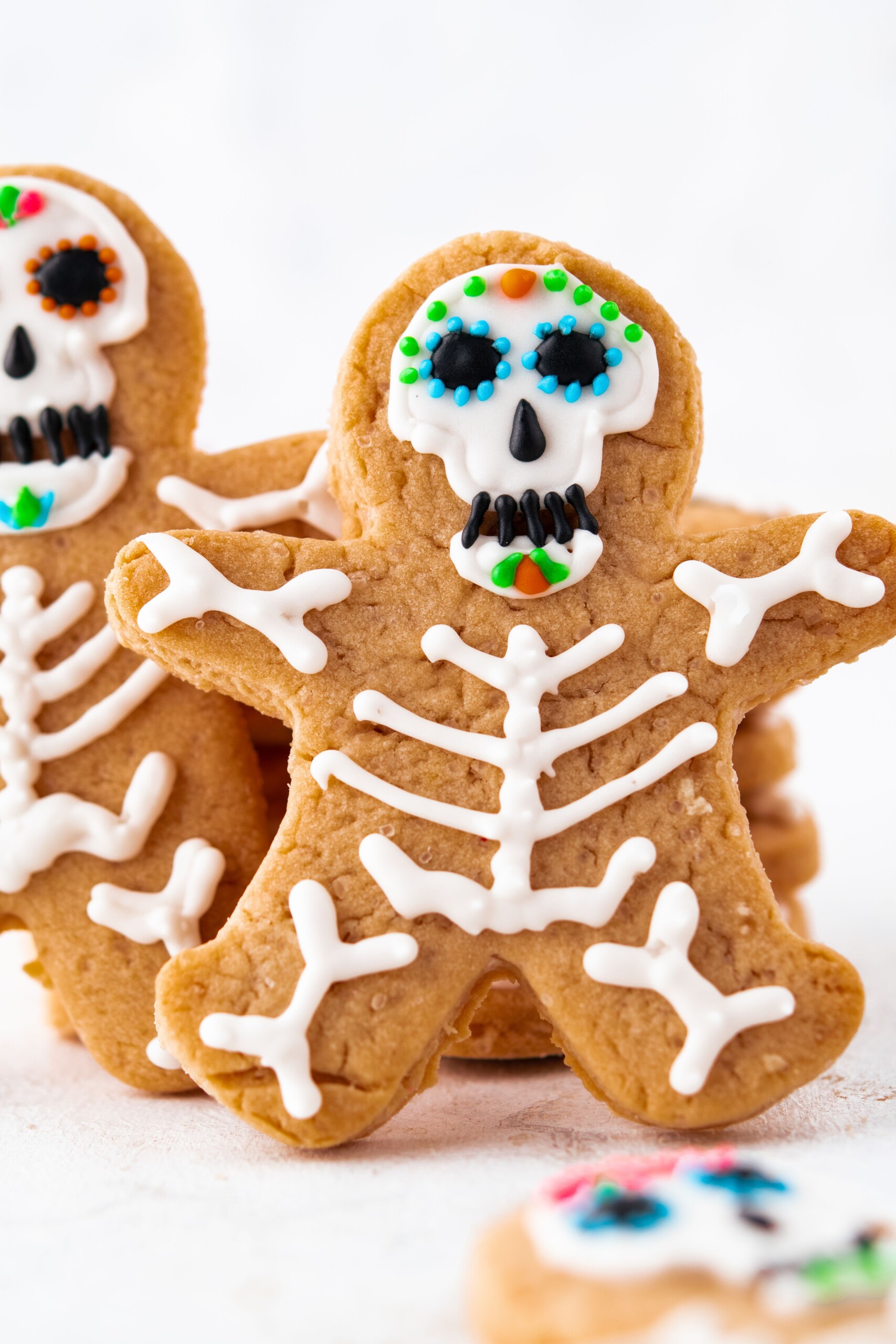 Halloween skeleton cookies on a white surface.