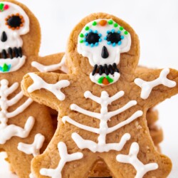 Halloween skeleton cookies on a white surface.