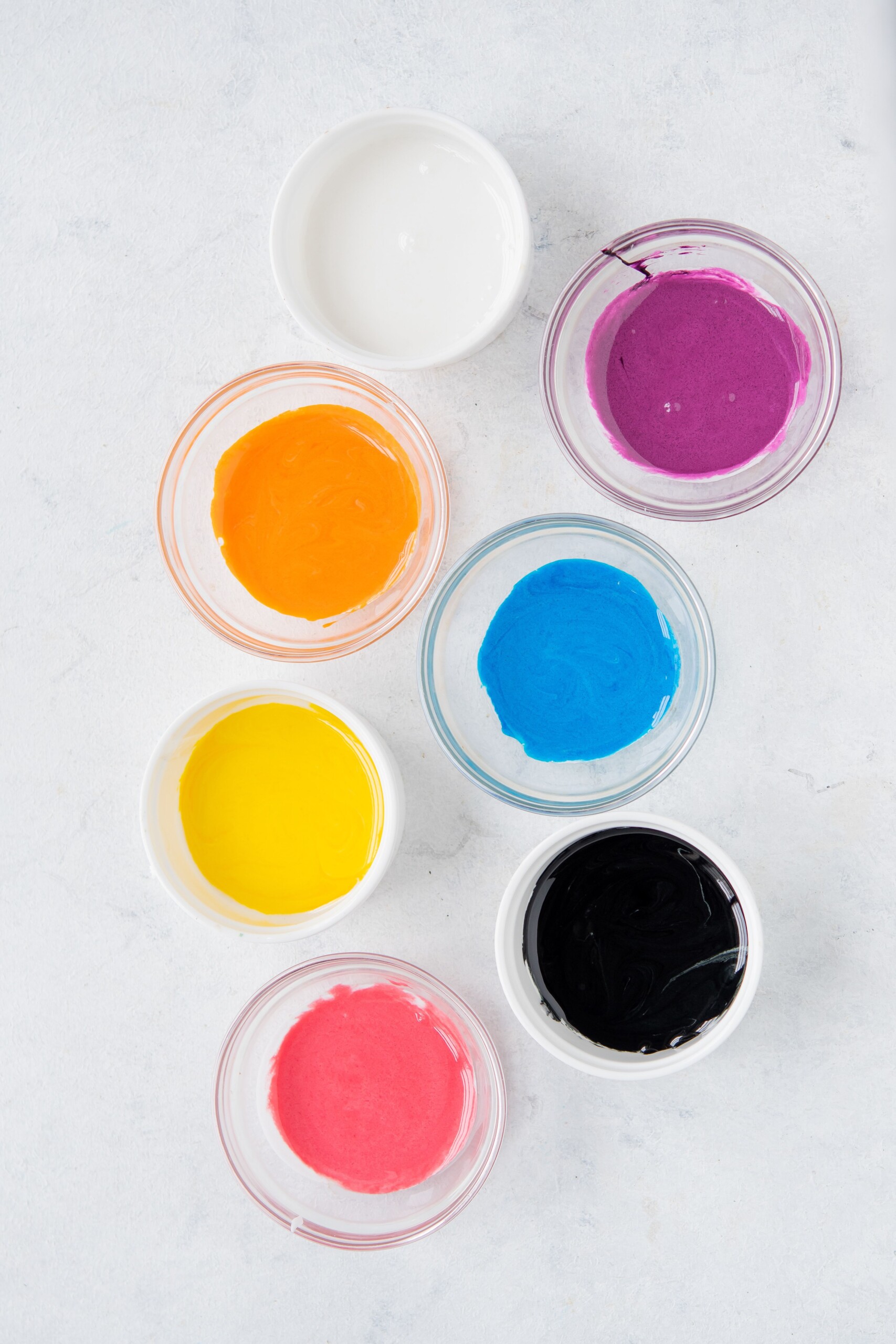 Royal icing in bright colors in small glass bowls