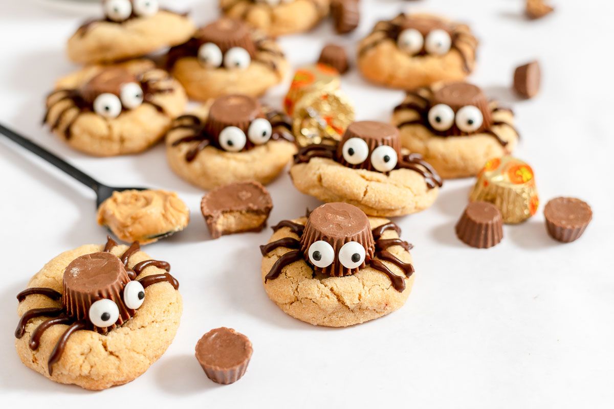 Peanut butter spider cookies on a white surface.