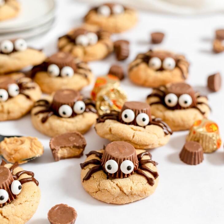 Peanut butter spider cookies on a white surface.