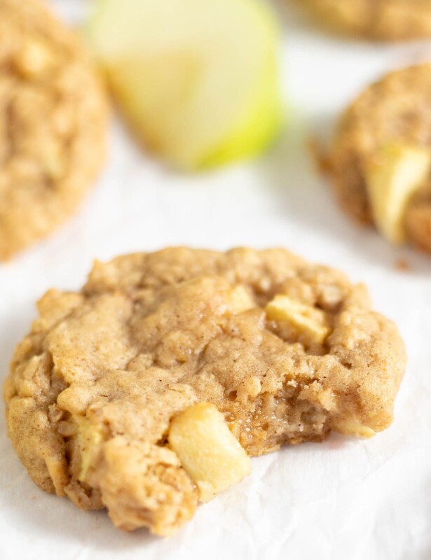 Apple oatmeal cookies on a white surface, with sliced green apples nearby