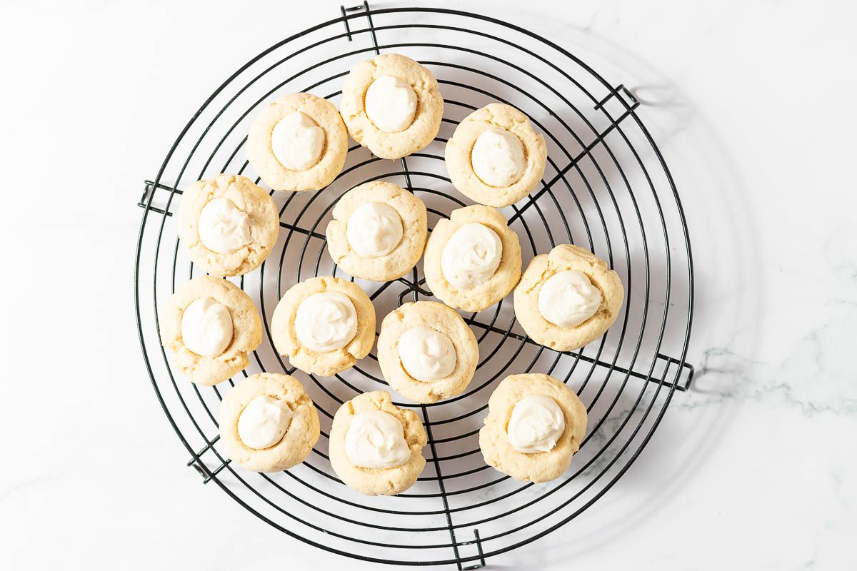 A round black wire cookie rack, with eyeball cookies being decorated on top