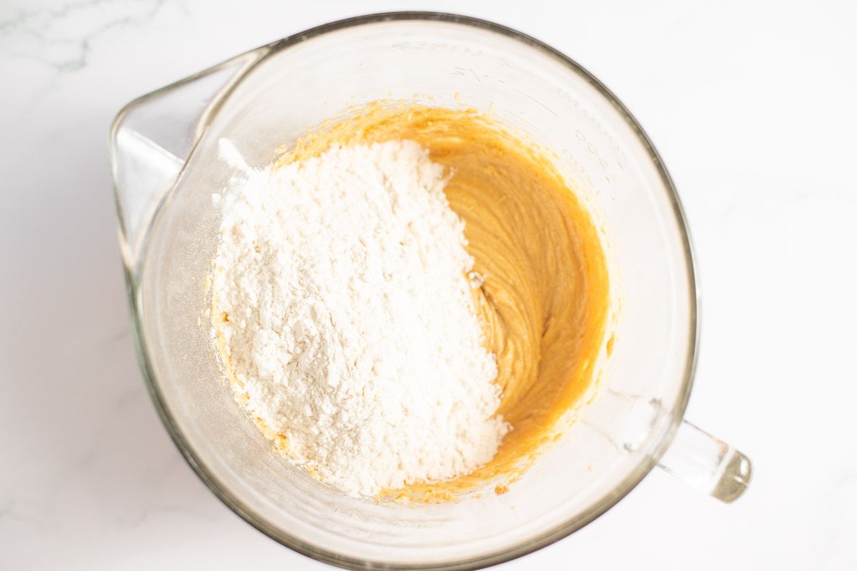 Peanut butter cookie ingredients in a glass mixing bowl