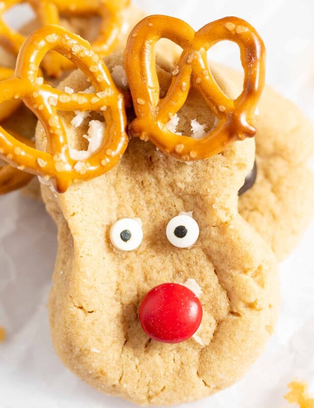 Peanut butter reindeer cookies on a baking sheet lined with parchment.