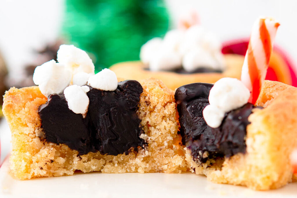 Hot chocolate cookie cups on a white surface.