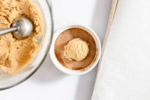 Overhead view of peanut butter snickerdoodle dough ball in cinnamon sugar bowl