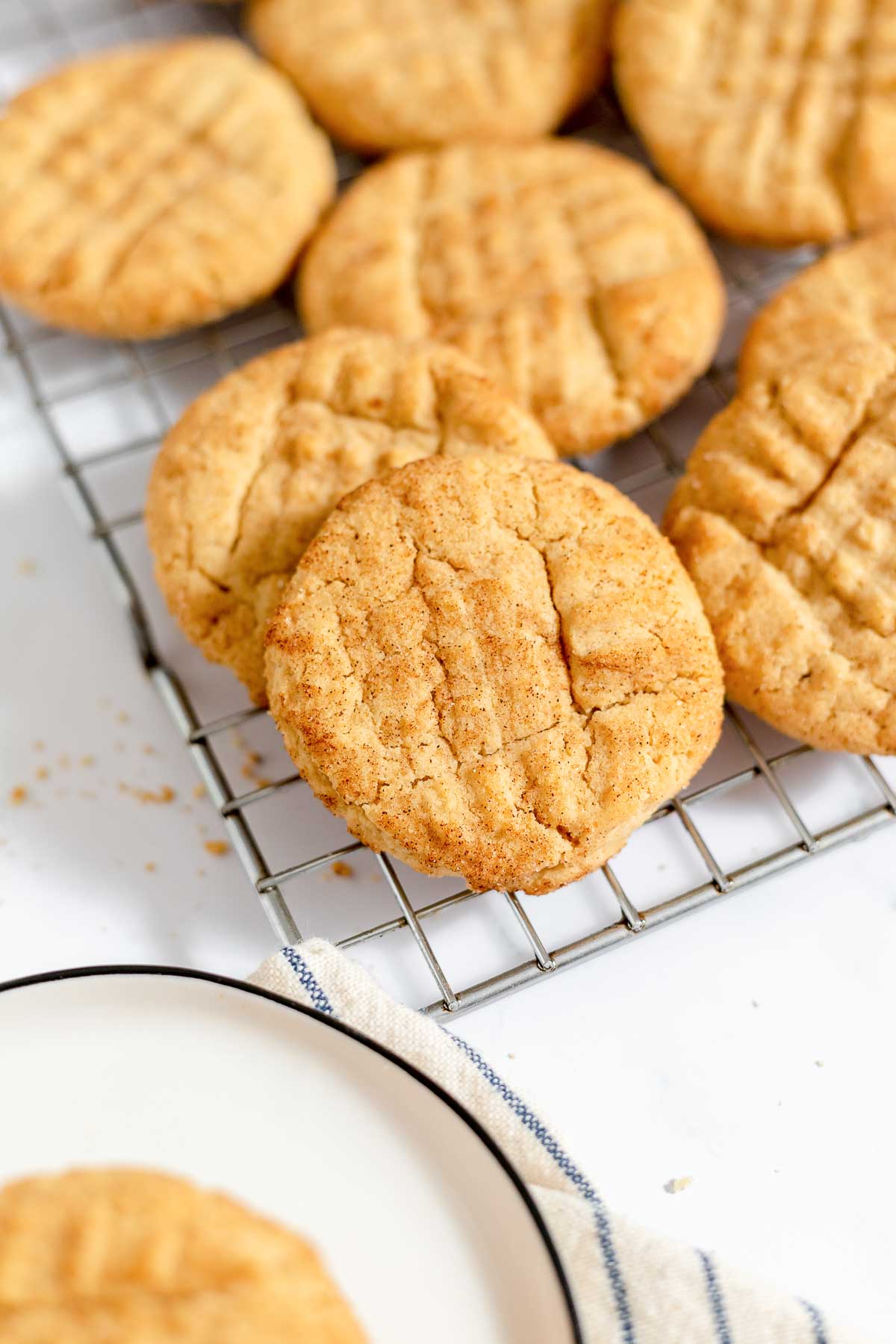 Peanut butter snickerdoodles on wire rack and plate