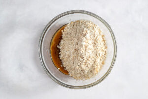 Overhead view of dry ingredients added to wet ingredients in mixing bowl