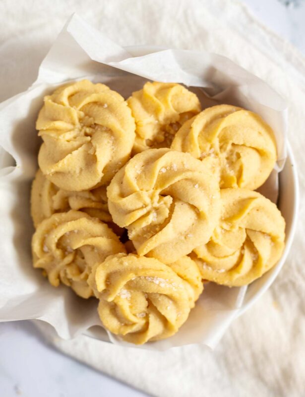 Overhead view of Danish butter cookies in parchment-lined bowl